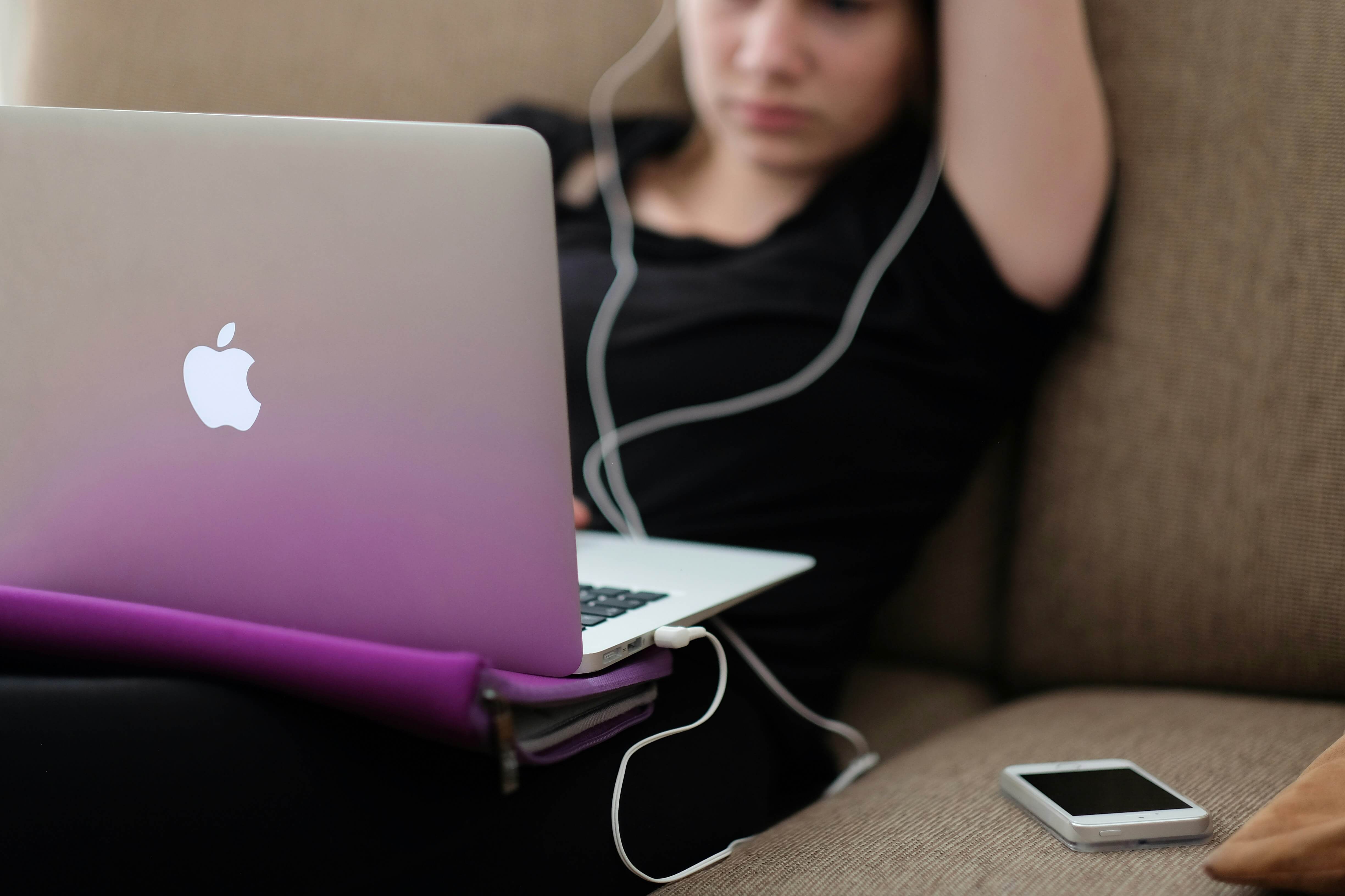 woman on sofa working on laptop - Assessment Apps for Teachers