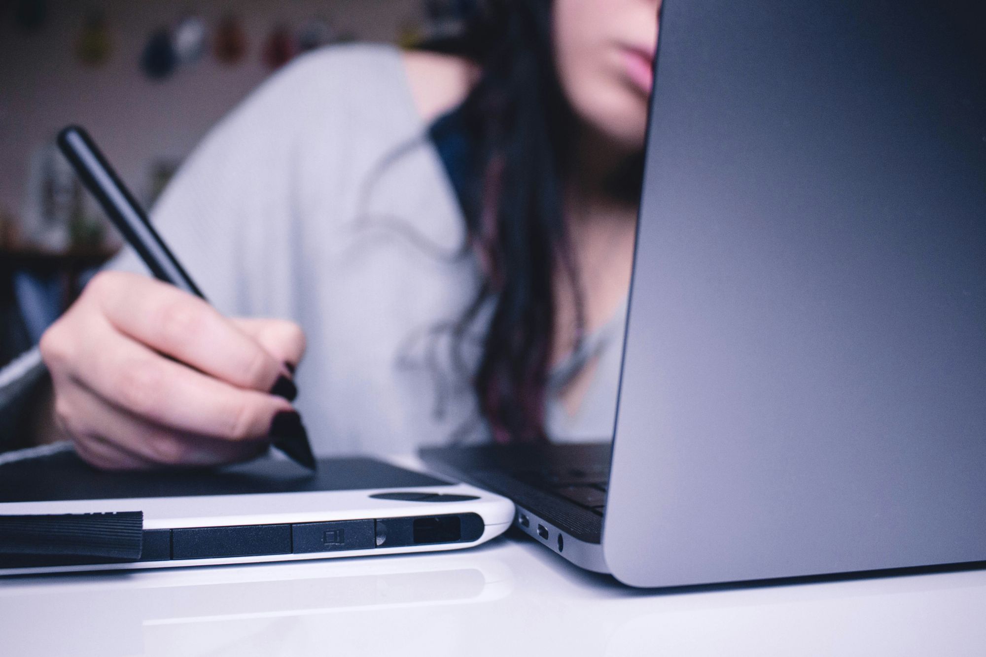 woman working on laptop and taking notes - Online Assessments for Students