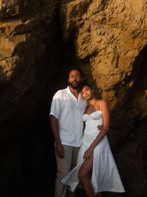 couple looking out behind a back drop of a rocky cove