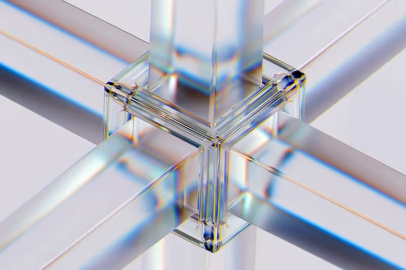 Close-up of a transparent glass-like geometric structure with intersecting rectangular beams forming a cross shape.