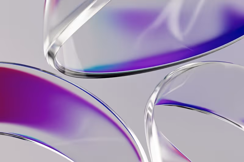 Close-up of translucent curved surfaces with purple and blue reflections on a light background.