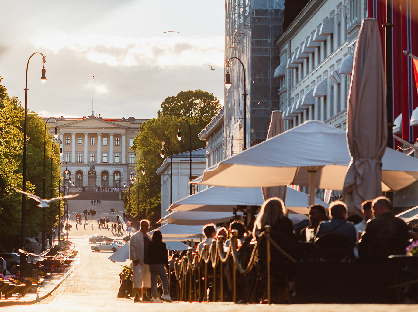 Karl Johan i solskinn med fullsatte uteserveringer og slottet i bakgrunnen