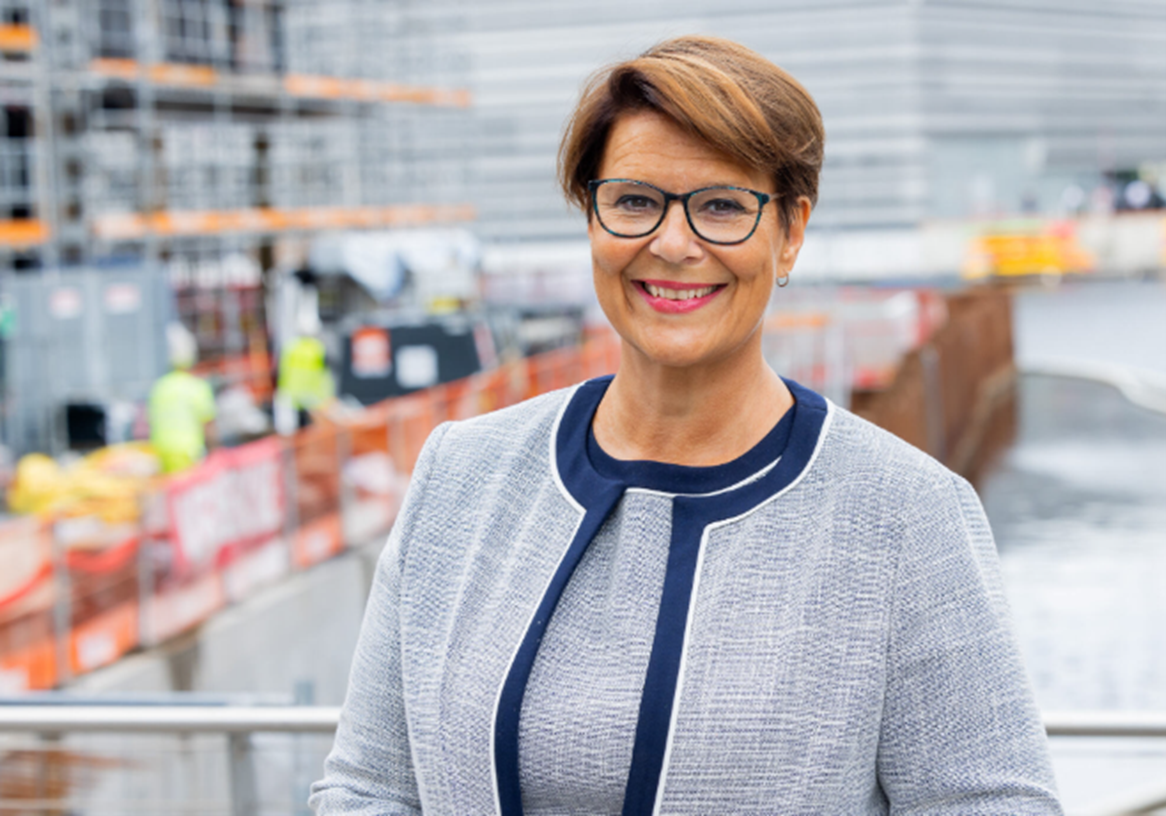 portrett av smilende tone tellevik dahl foran en byggeplass