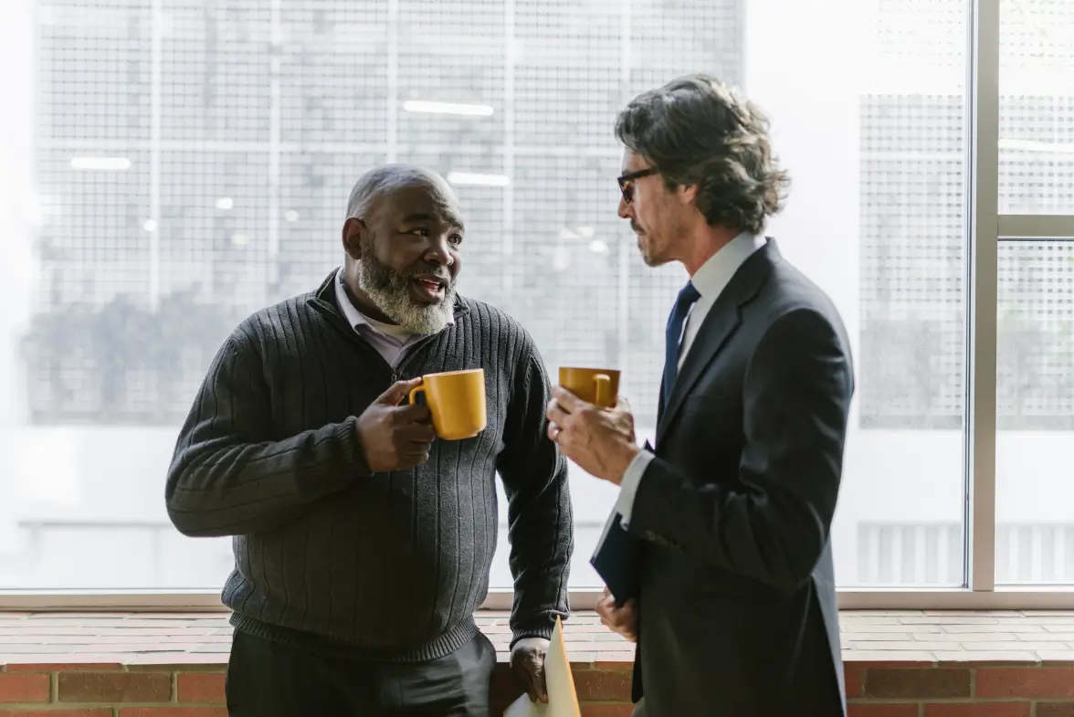 Two professionals having an informal conversation about coaching training experience