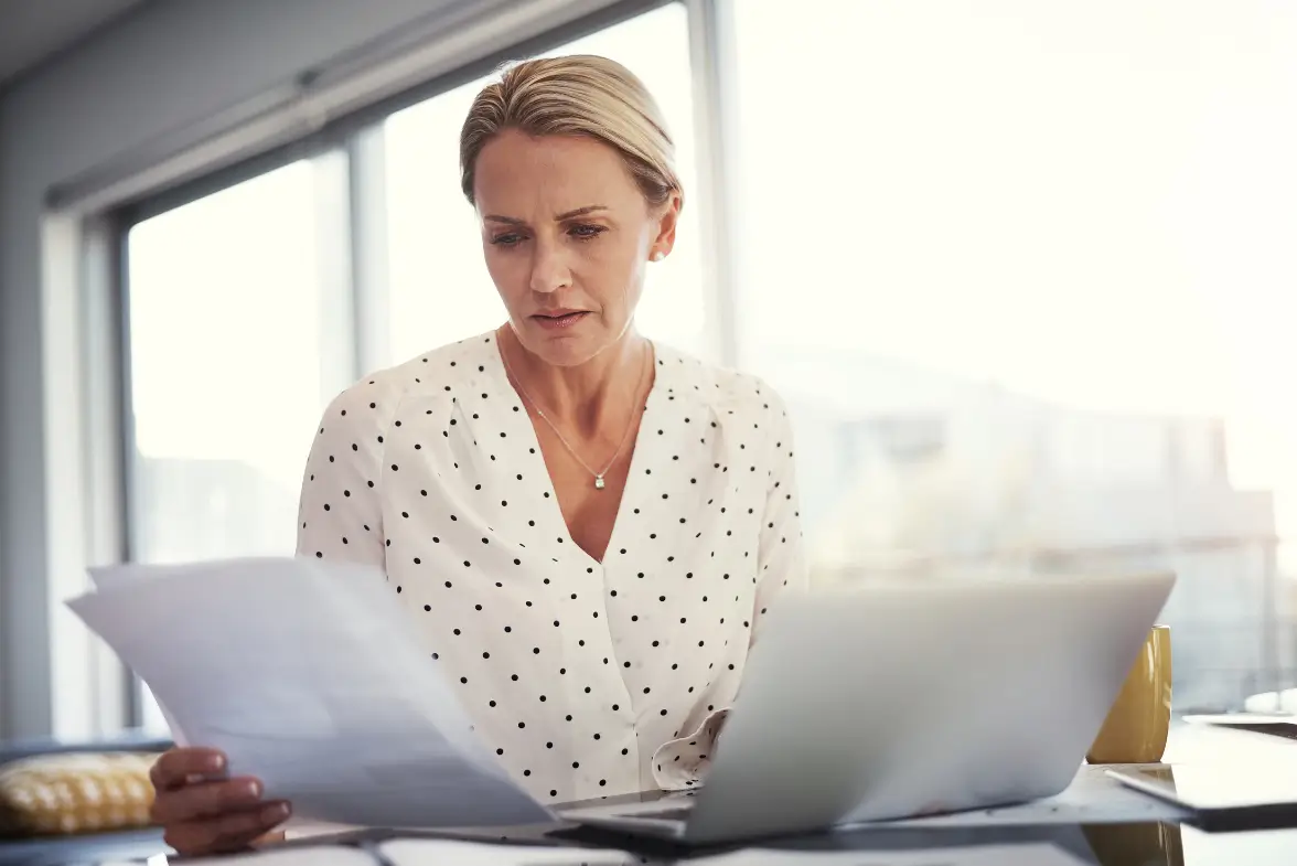 A professional carefully reviewing a coaching school's program details before making an enrollment decision.