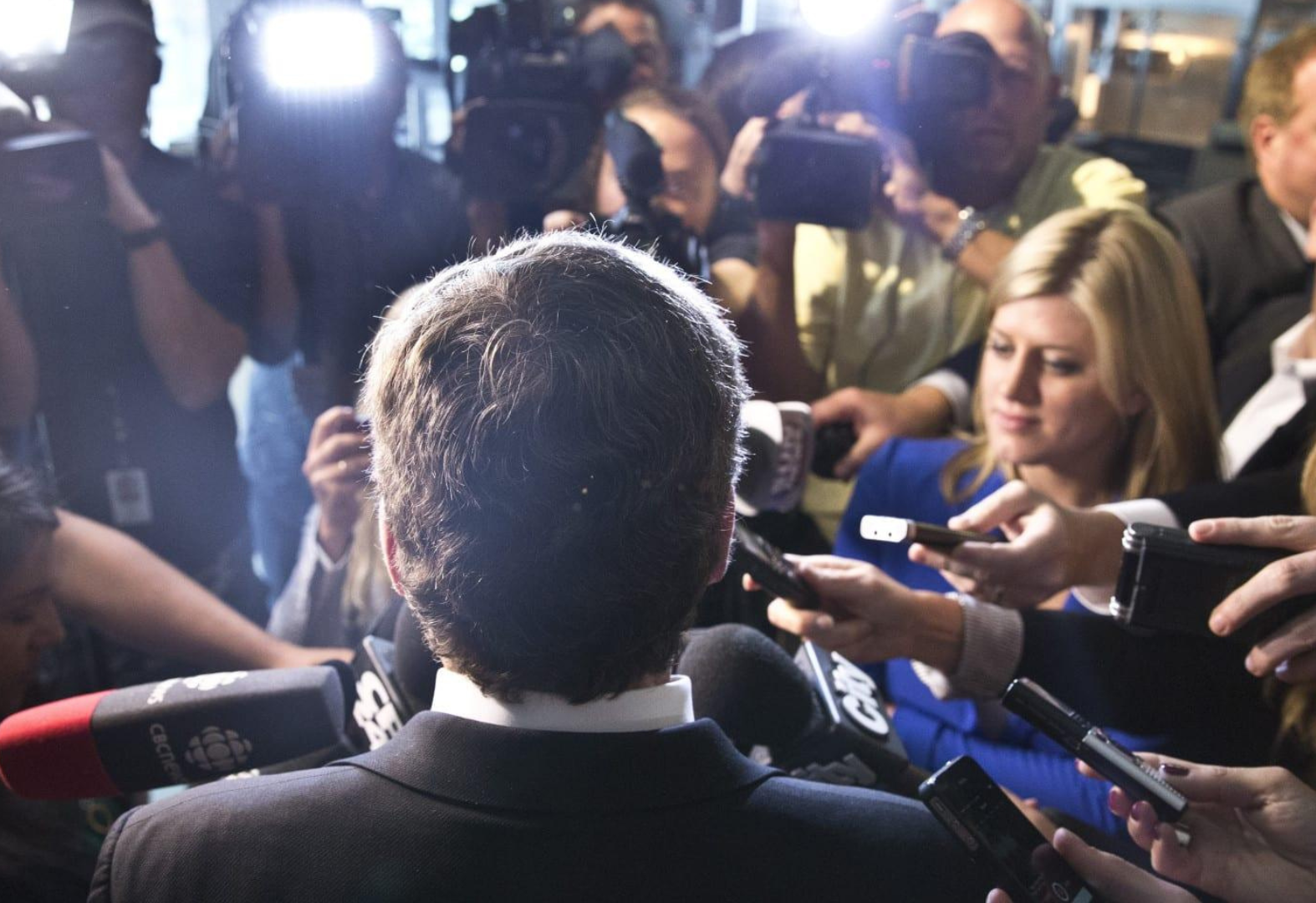 A political leader being questioned by reporters during a crisis