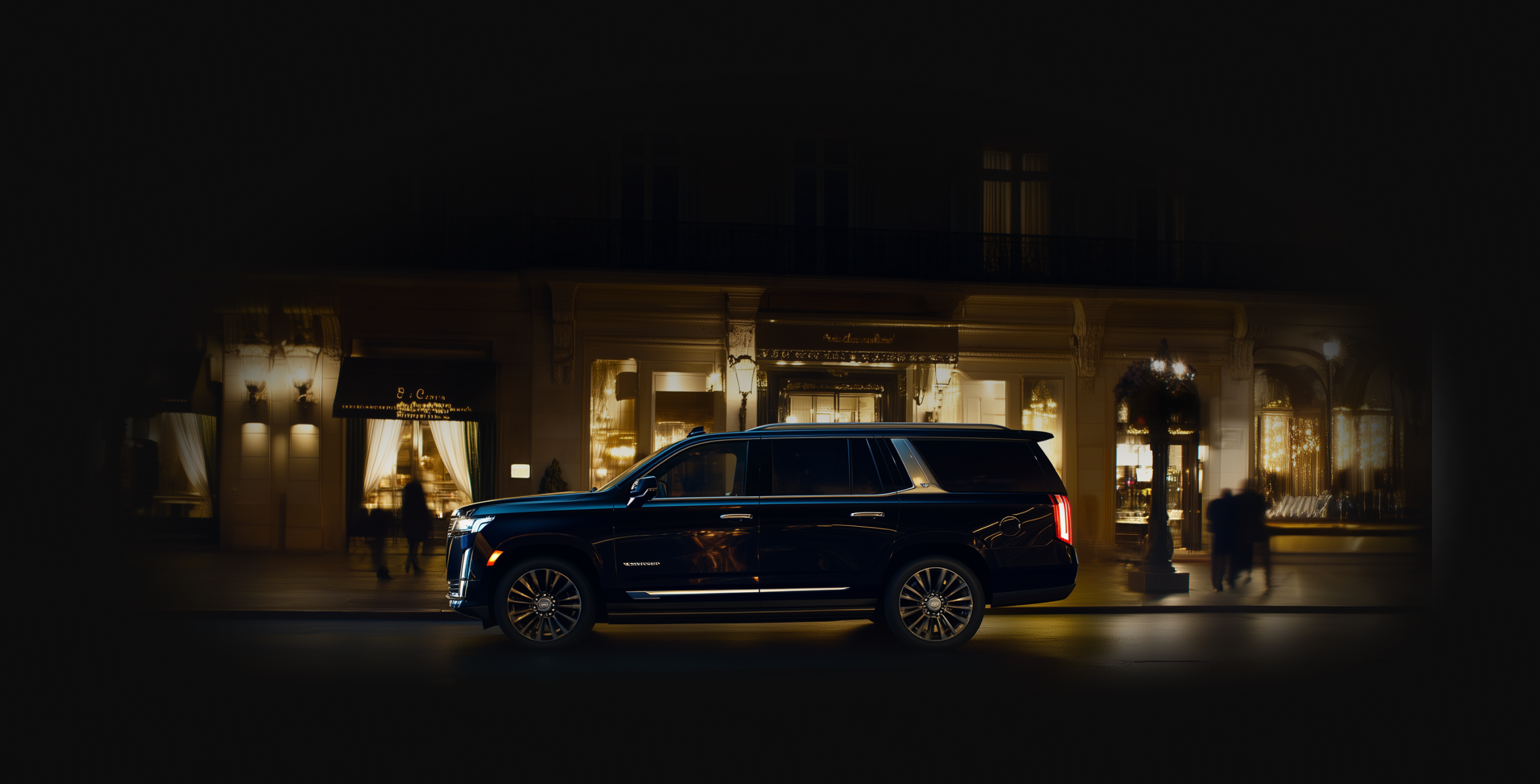A sleek black Cadillac Escalade limousine parked in front of a luxurious, well-lit building at night