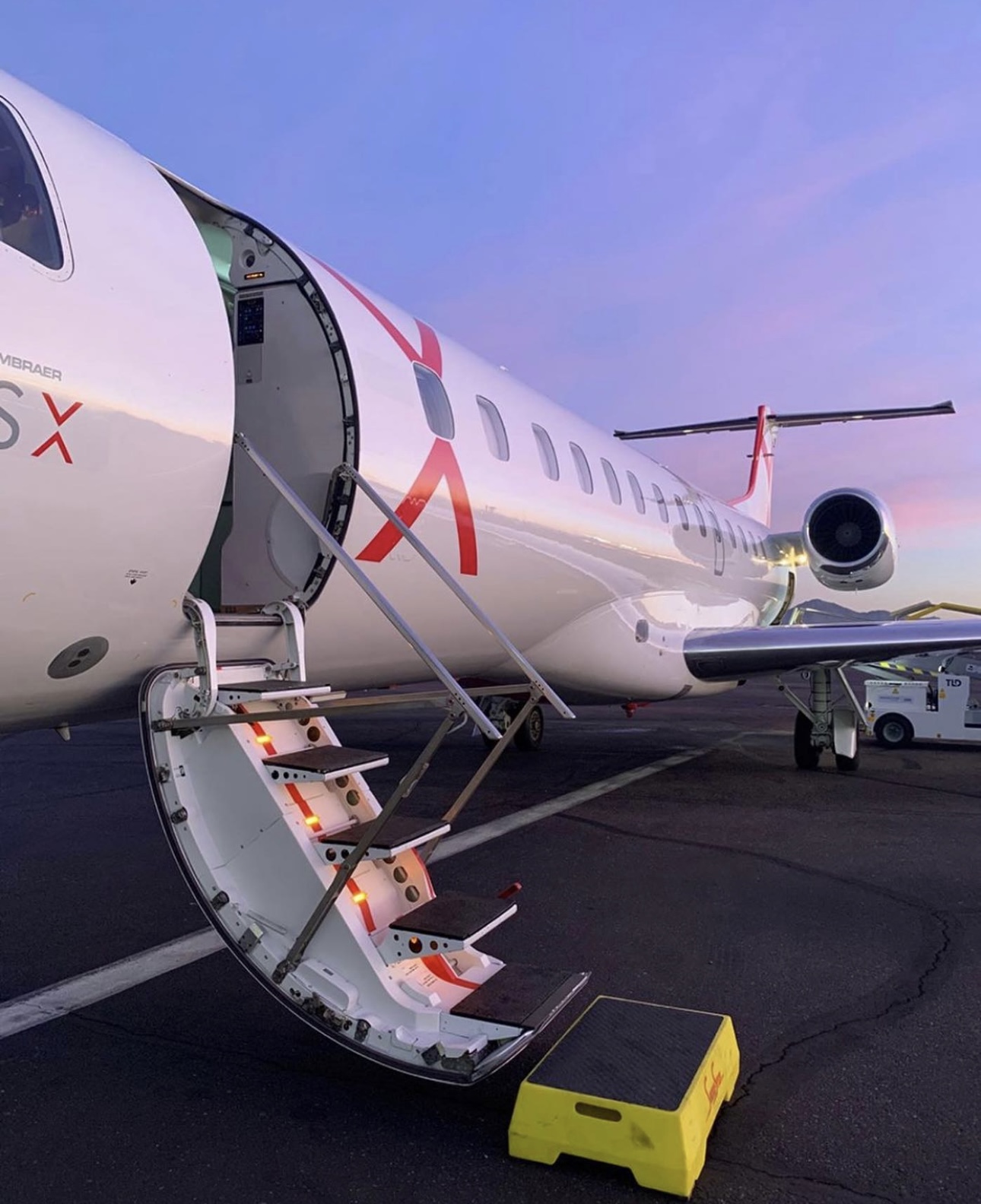 JSX private jet with open door at night, offering seamless travel experience with luxury limo service to JSX Opa Locka.