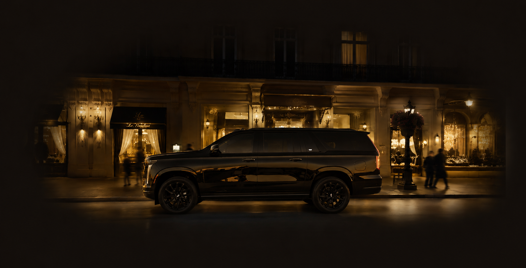 A sleek black Cadillac Escalade limousine parked in front of a luxurious, well-lit building at night