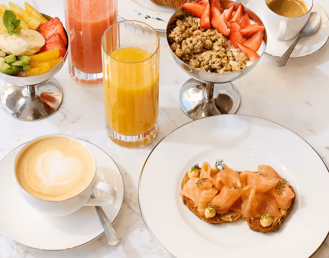 Salle de petit-déjeuner lumineuse avec tables élégantes et buffet gourmand - Hôtel Noucha