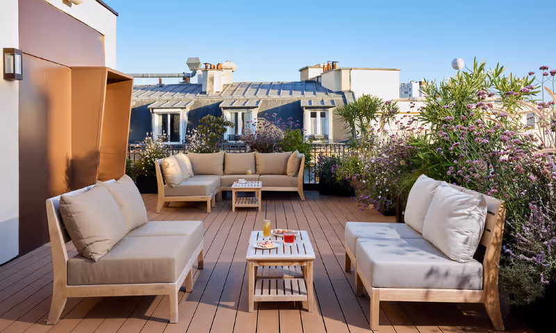 Sur un rooftop dans le 16ème arrondissement, un jardin verdoyant avec espaces ombragés, fleurs colorées et coin détente pour vous évènements- Hôtel Noucha