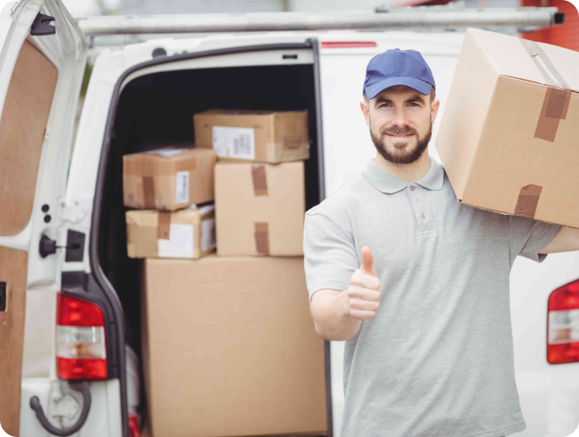 Un déménageur professionnel en uniforme orange soulevant un grand carton depuis un camion lors d’un déménagement d’objets lourds par une journée ensoleillée.