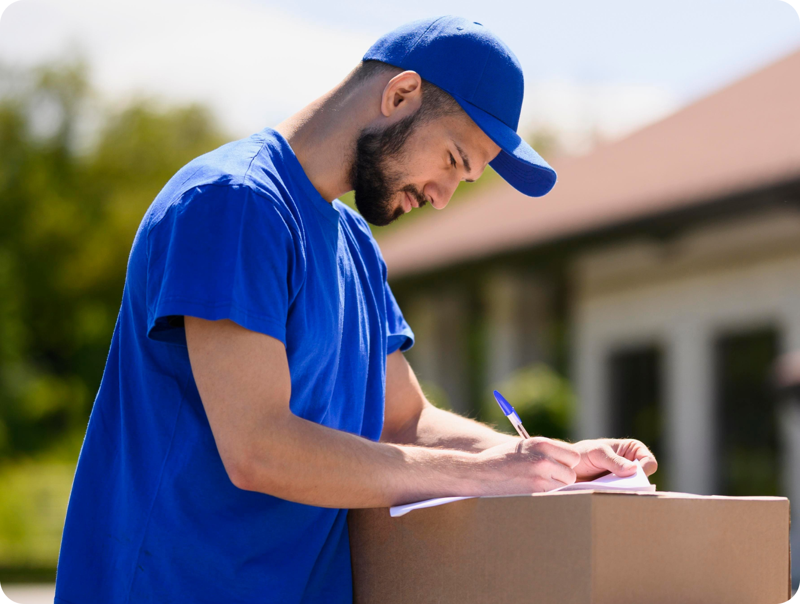 Deux déménageurs en combinaison bleue et casquette blanche chargeant soigneusement des cartons étiquetés "Fragile" dans une camionnette.