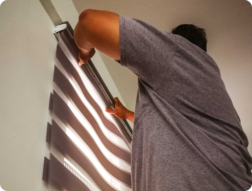 Deux déménageurs en combinaison bleue et casquette blanche chargeant soigneusement des cartons étiquetés "Fragile" dans une camionnette.