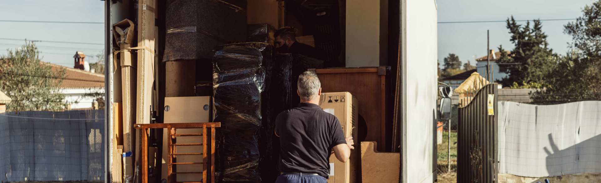 Des déménageurs chargeant un grand canapé dans un camion, en veillant à la sécurité et à la protection des meubles lors d’un déménagement résidentiel à Bois-des-Filion.