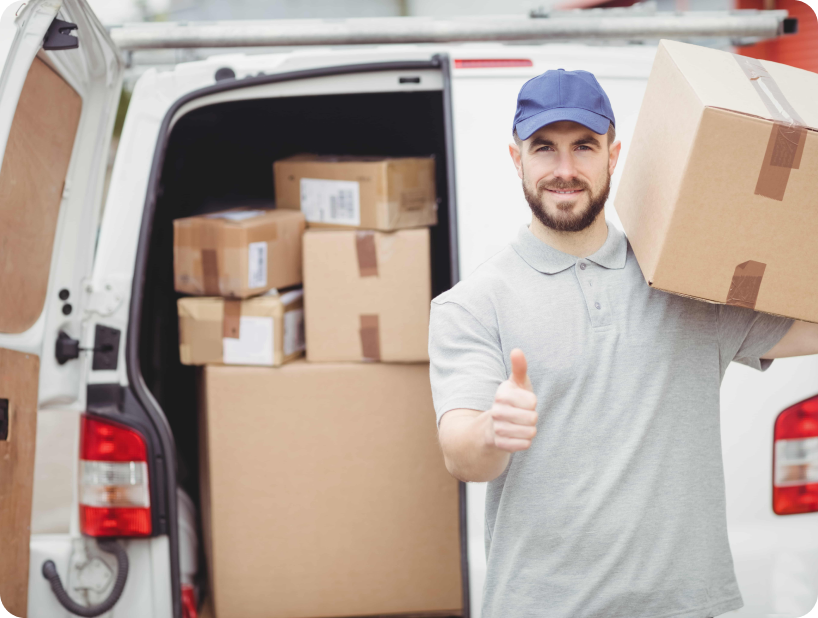 Un déménageur en hoodie rouge Déménagement WillGo déchargeant du matériel d’un camion près d’un immeuble résidentiel.