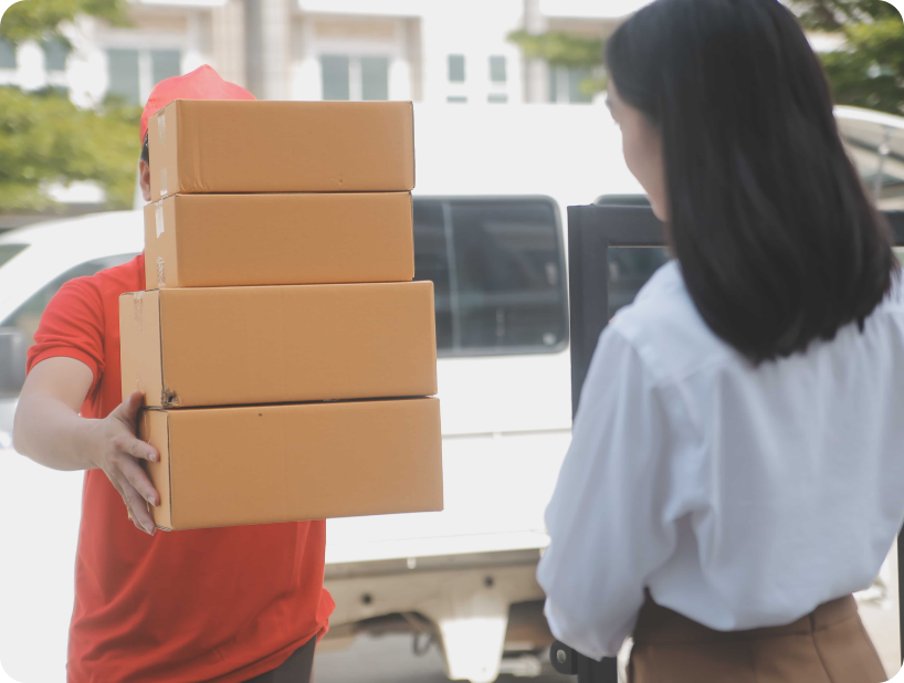 Deux déménageurs en combinaison bleue et casquette blanche chargeant soigneusement des cartons étiquetés "Fragile" dans une camionnette.