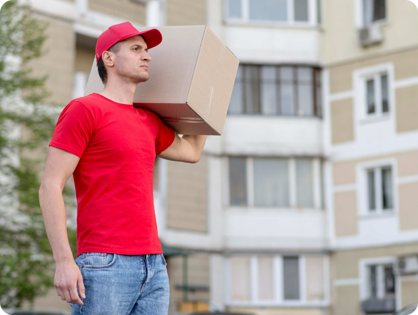 Deux déménageurs en combinaison bleue et casquette blanche chargeant soigneusement des cartons étiquetés "Fragile" dans une camionnette.