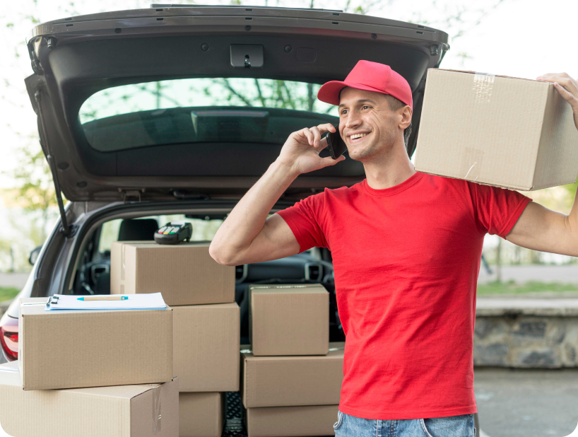 Deux déménageurs en combinaison bleue et casquette blanche chargeant soigneusement des cartons étiquetés "Fragile" dans une camionnette.