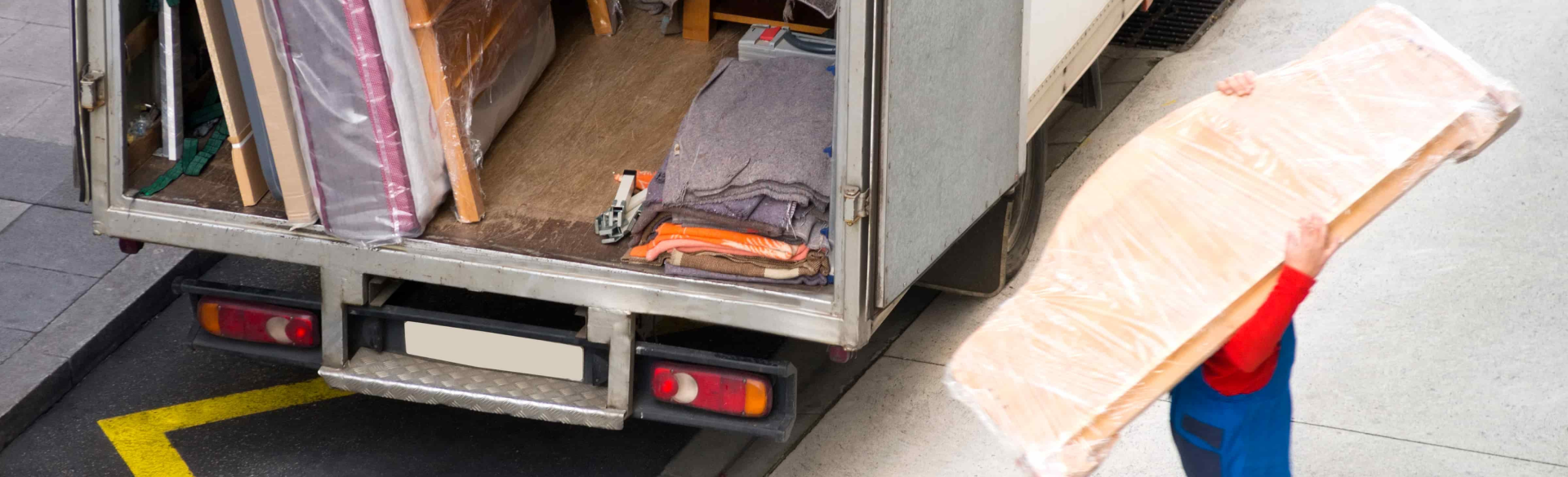 Nombreuses boîtes de déménagement en carton empilées devant des maisons résidentielles lors d'un déménagement.