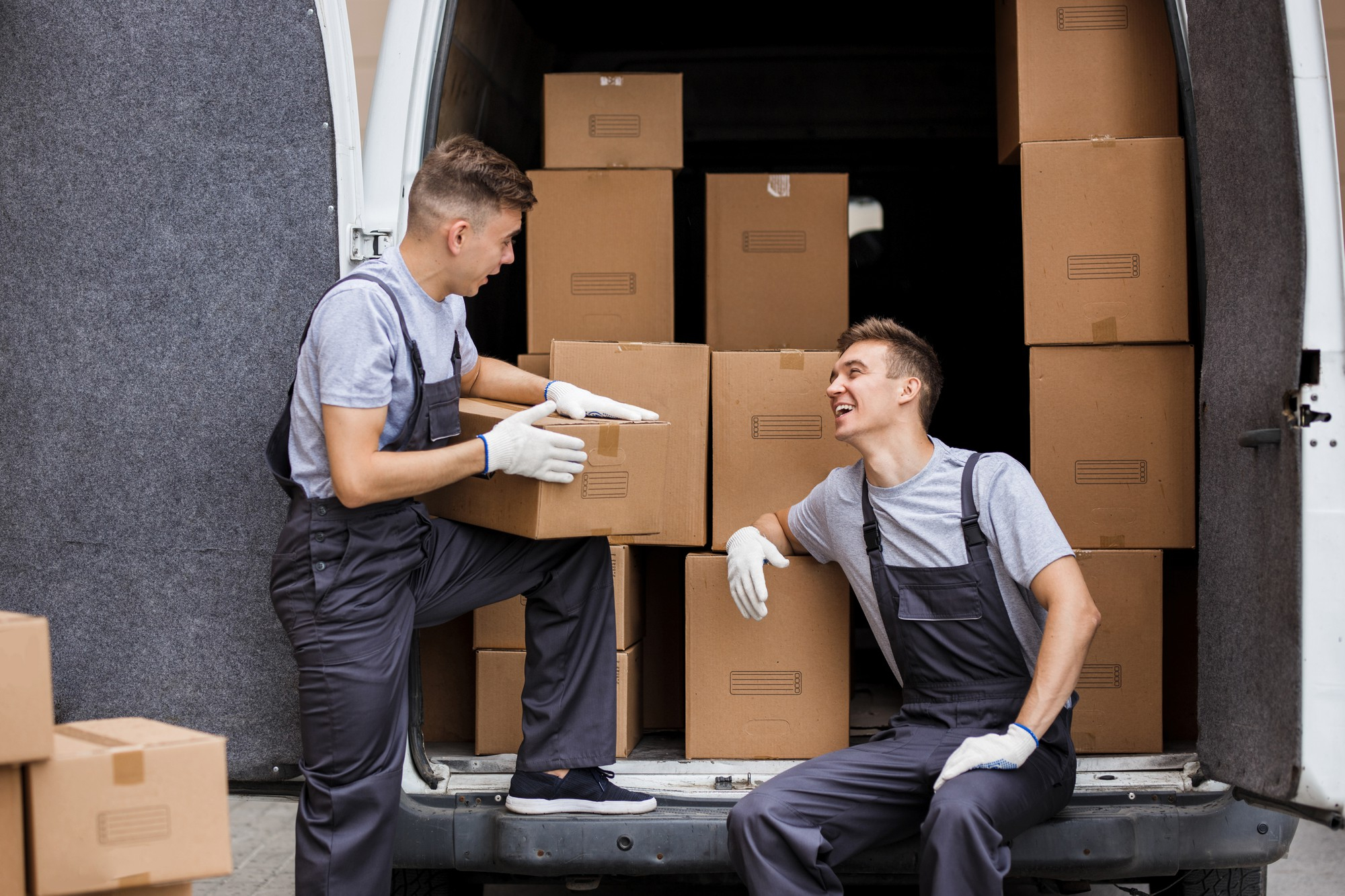 Deux déménageurs professionnels prenant une pause lors d'un déménagement appartement Montréal.