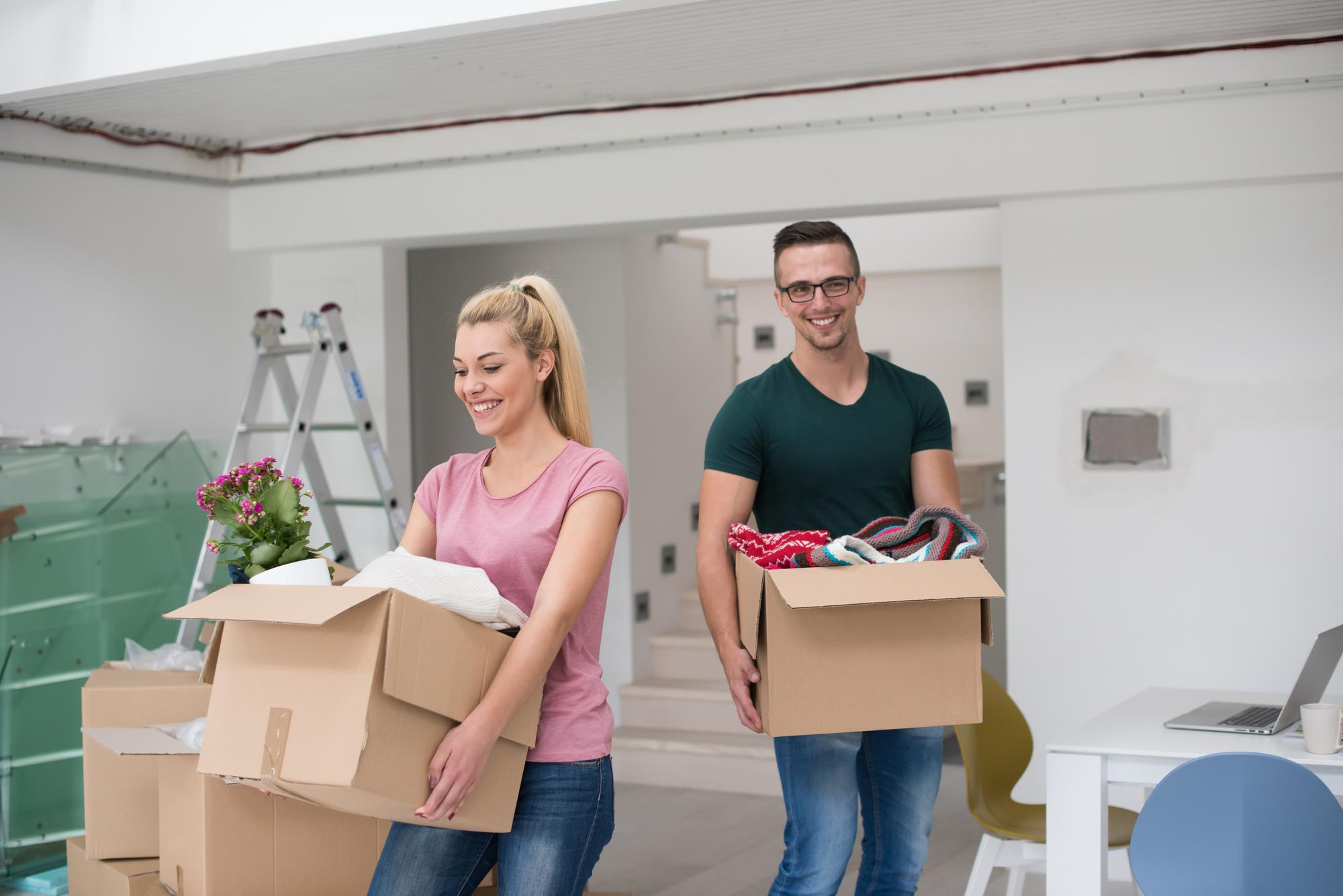Couple transportant des boîtes dans leur nouveau logement lors d'un déménagement résidentiel Québec.