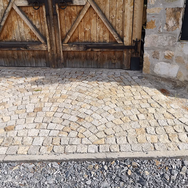 Ein gepflasterter Eingangsbereich mit kleinen Steinen.