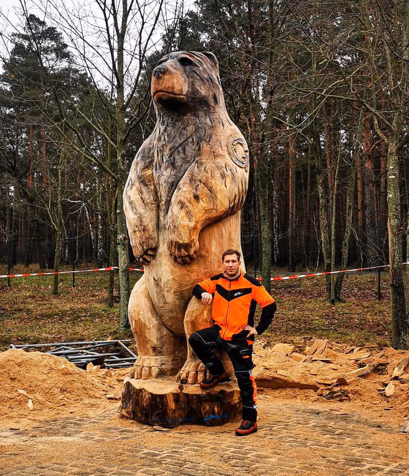 Oliver Leßmann von Olliwood vor einem riesengroßen Holzbären