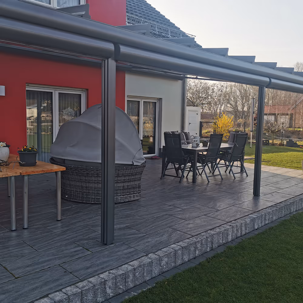 Eine dekorative Terrasse und Rasen davor.
