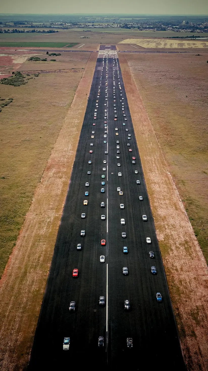 Drone shot of a straight road and carsup cars driving.