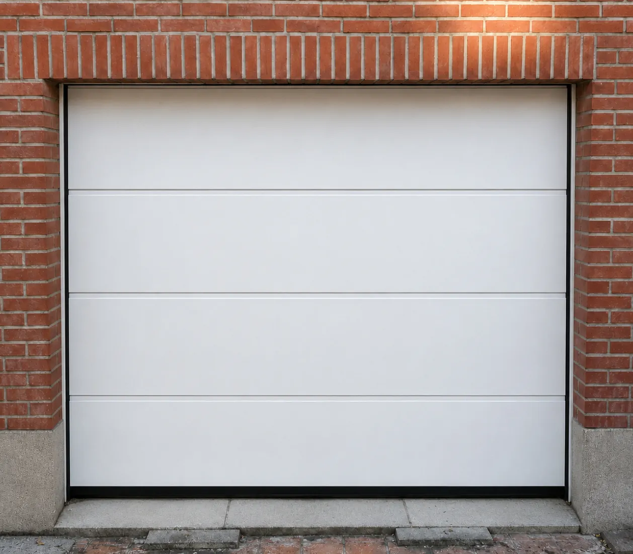 Porte de garage blanche moderne encadrée de briques rouges sur trottoir en béton.