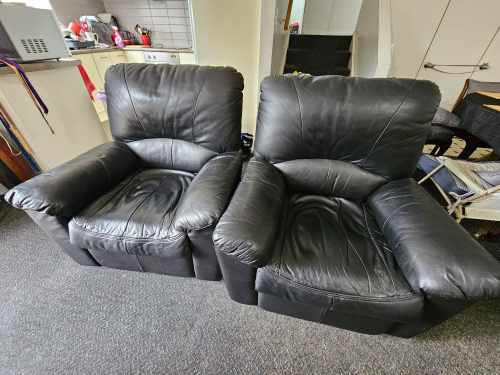 Two black leather recliner chairs.