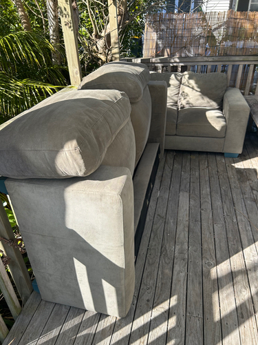 Two light gray sofas with large cushions.