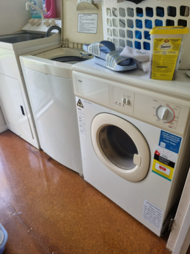 Washing machine, dryer, bottle of laundry detergent, folded towels.