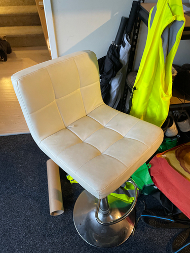 Bar stool with a white padded seat and a chrome base.