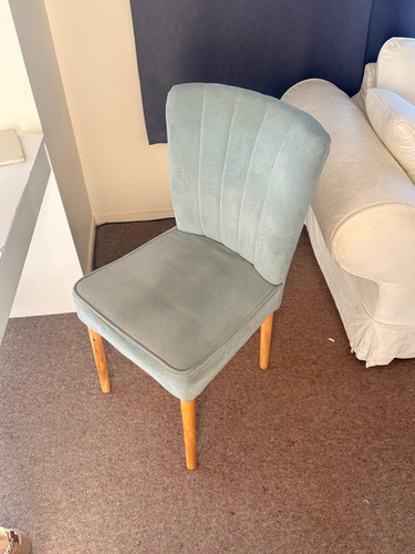 Light blue upholstered chair with wooden legs.