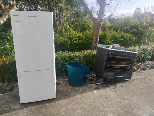 White refrigerator, black oven, blue trash can.