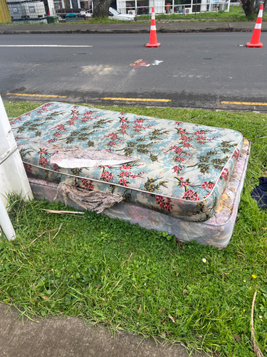 Two discarded mattresses with floral patterns.