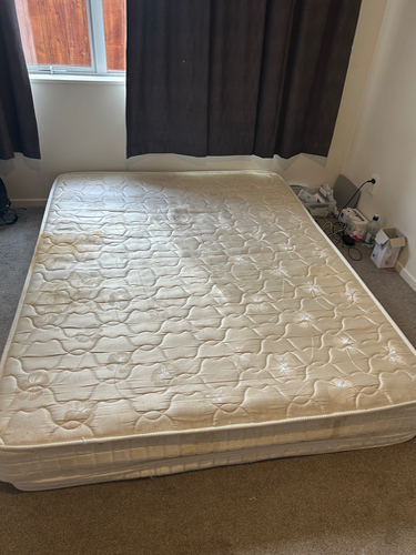 Twin-sized mattress with visible stains.