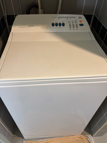 Top-loading washing machine with control panel and buttons.