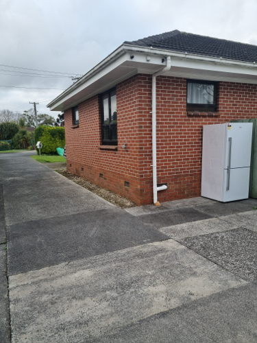 Brick house exterior, white refrigerator.