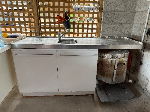 Stainless steel sink, white cabinetry, cooking stove.