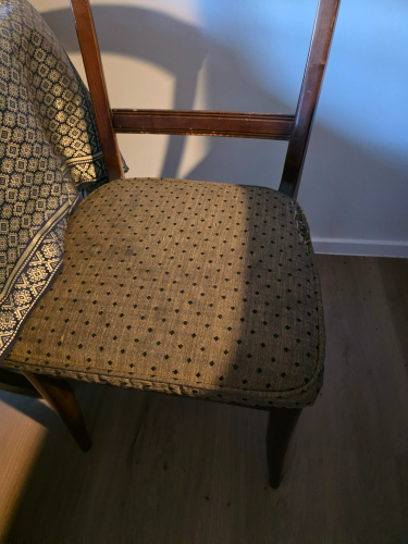 Chair with a patterned upholstered seat and wooden frame.