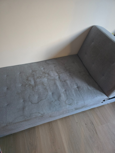 Gray couch with stains.