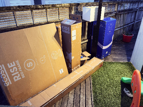 Cardboard boxes for a bed frame and a kids' furniture set.