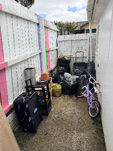 Bicycle, black garbage bags, metal cart, small table, suitcase.