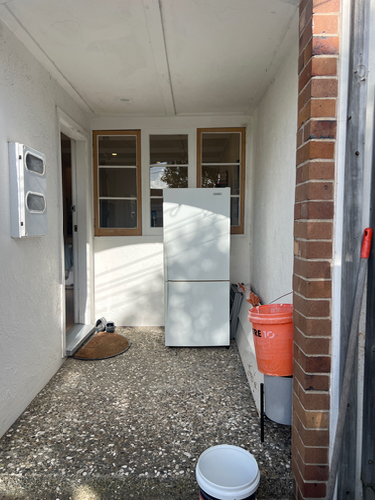 white refrigerator, orange bucket, round mat