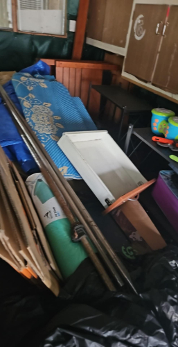 Wooden panels, blue rolled mat, white door, green mat, purple box, plastic toys.