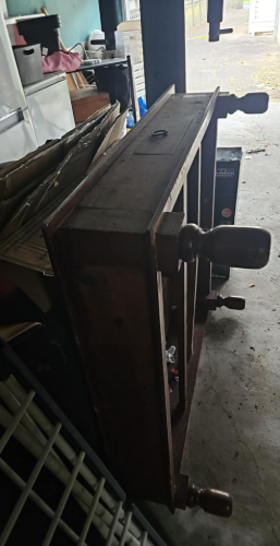 Wooden dresser with knobs and drawer openings.