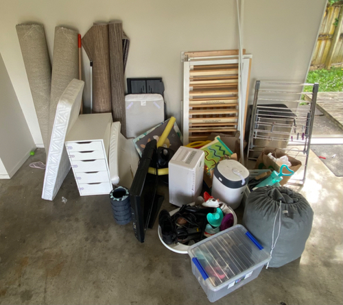 Mattresses, shelving unit, storage bins, vacuum cleaner, plastic containers, clothes rack, assorted household items.